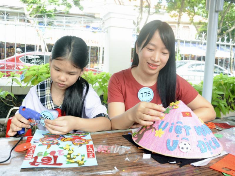 Hình ảnh những người bạn vui vẻ chúc Tết nhau trong không khí mùa xuân, có cành đào, cành mai